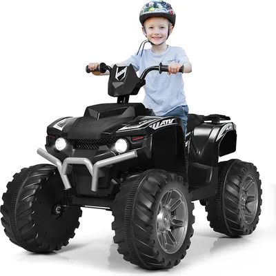A young boy wearing a helmet rides a black electric ATV.
