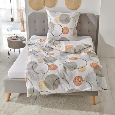 A bed with bedding and a pillow, set in a bedroom.