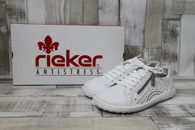 A pair of white Rieker sneakers is displayed next to its original packaging box.