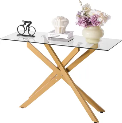 A glass console table with a gold metal base, decorated with a bicycle figurine, books, a vase, and flowers.