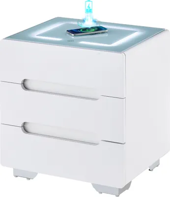 A white nightstand with a glowing top surface and a smartphone charging on it.