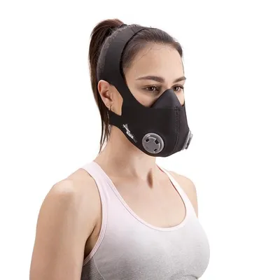 A woman wearing a black training mask and a white sports bra, shown from the chest up against a white background.