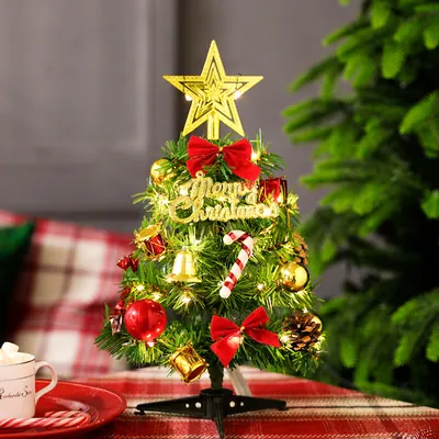 A decorated mini Christmas tree on a table with a red and white checkered tablecloth.