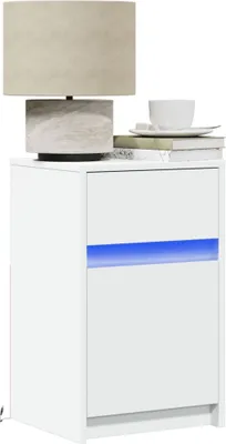 A white nightstand with a lamp and a cup on top.