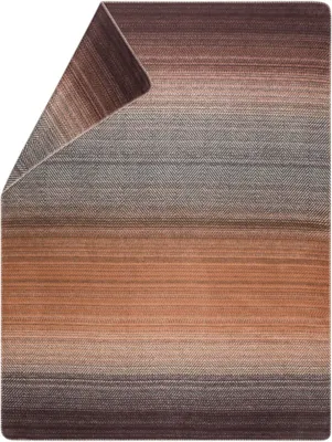 A close-up view of a folded blanket with a gradient color pattern.