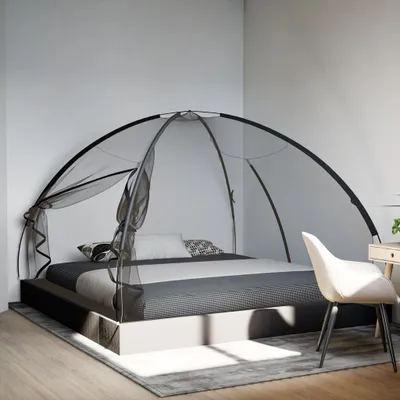 A bedroom scene with a bed and a mosquito net.