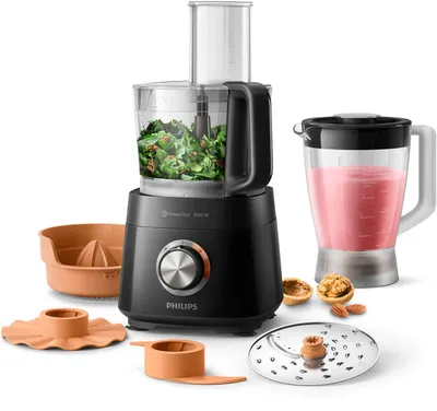 A collection of kitchen appliance attachments and accessories are displayed around a black Philips food processor and blender.