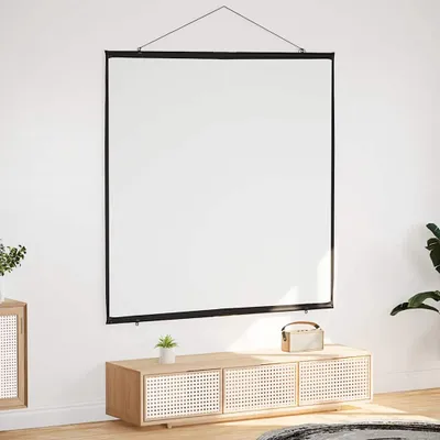 A white projection screen is hanging on a white wall above a wooden media console with a small plant and a speaker on it.