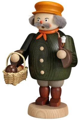 Ein Räuchermann in traditioneller Kleidung hält ein Körbchen mit Waldpilzen in der einen Hand und eine Pfeife in der anderen während er auf einem runden Holzsockel steht
