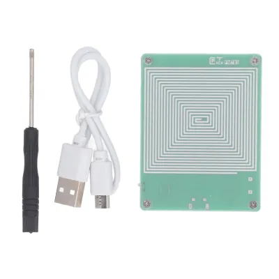 A flat lay of electronic components including a screwdriver, a USB cable, and a circuit board with a coil.
