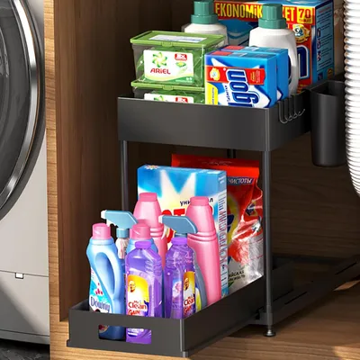 A two-tier sliding drawer organizer filled with various cleaning products, placed under a sink or in a cabinet.