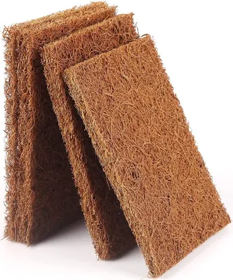 A stack of brown, fibrous pads leaning against each other on a white background.