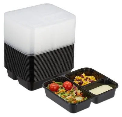 A stack of black food containers with clear lids, and one open container filled with salad, corn, beans, and dressing.