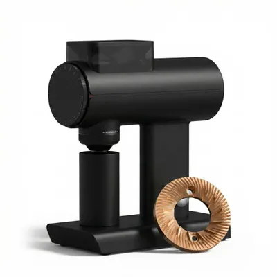 A black electric coffee grinder with a detached burr set in front of it, displayed on a white background.