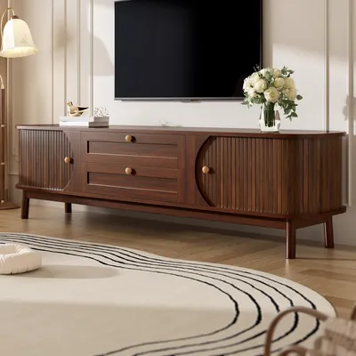 A TV stand with drawers and doors in a living room setting.