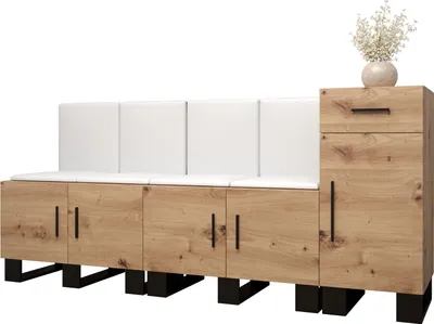 A long wooden storage bench with white upholstered panels and a small cabinet with a drawer on the right, topped with a vase of flowers.