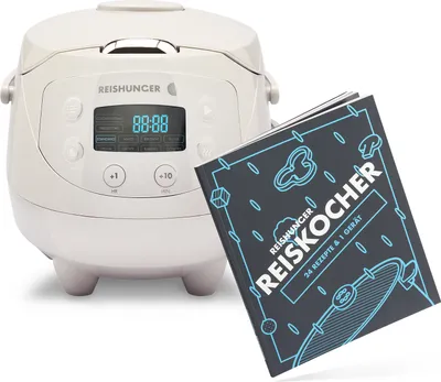 A white rice cooker and a cookbook are placed next to each other against a white background.