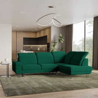 A modern living room with a green sectional sofa, kitchen in the background, and large windows.