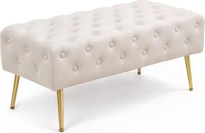 A tufted bench with gold legs on a white background.