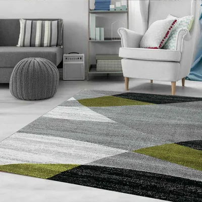 A modern living room with a sofa, armchair, and a geometric patterned rug.