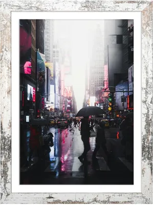A rainy city street scene with people walking and cars driving.