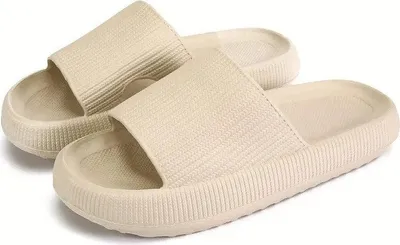 Paar beige Cloud-Slides mit strukturierten Riemen und dicken Sohlen, aus leicht erhöhtem Winkel betrachtet