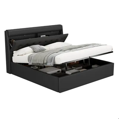 A black upholstered storage bed with the mattress and bedding on top, and the storage compartment underneath open.