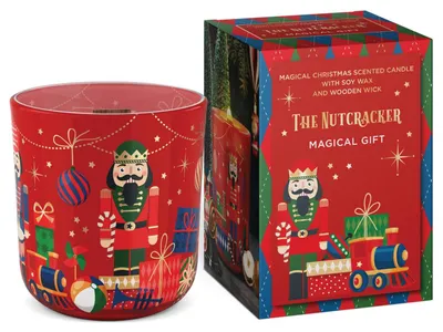 Rote Duftkerze im Glas mit Nussknacker-Motiv, Holzdocht, umgeben von Weihnachtsdekoration wie Spielzeugen und Geschenken. Verpackt in dekorativer rot-blau-grüner Geschenkbox mit Goldakzenten.