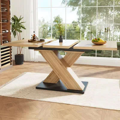 A dining room with a large wooden extendable table in the center, set against a backdrop of large windows overlooking greenery. A wine rack is visible on the left.