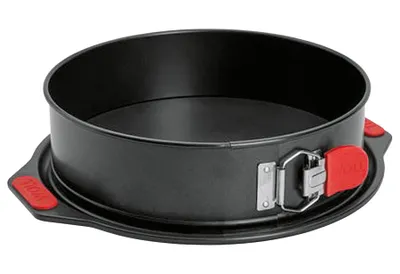 A black springform cake pan with red handles is shown against a white background.