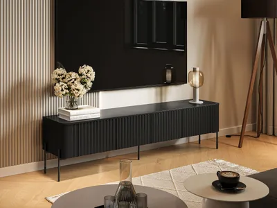 A modern living room with a black TV stand, a large TV, and decorative items.