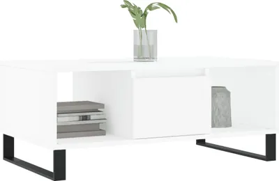 A white coffee table with black legs, featuring a vase with a plant and a decorative object.