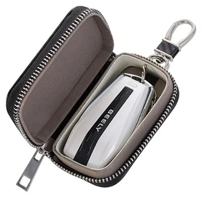 An open black car key case with a white and black car key inside.