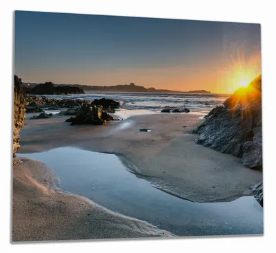 Produktbild von Wallario Herdabdeckplatte aus Glas, Größe 60 x 52 cm 1-teilig, Motiv Sonnenuntergang hinter einem Felsen am Strand