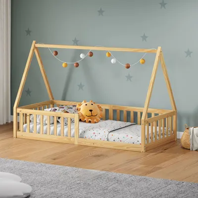 A child's bed with a wooden frame, bedding, and a lion-shaped pillow, set in a room with star-patterned walls.