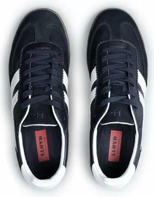 A top-down view of a pair of navy blue sneakers with white stripes.
