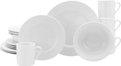 A collection of white ceramic dinnerware, including plates, bowls, and mugs, arranged on a white background.