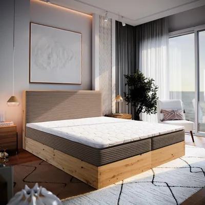 A bedroom scene with a large bed, artwork on the wall, and a window with a view.