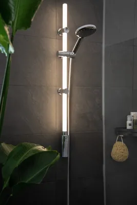 A modern bathroom shower with a sleek LED light bar and showerhead.