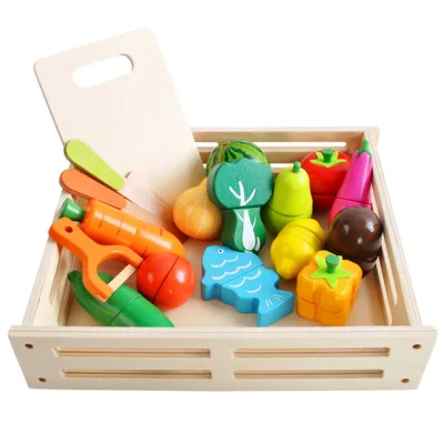 A wooden crate filled with toy fruits and vegetables, along with a wooden cutting board.