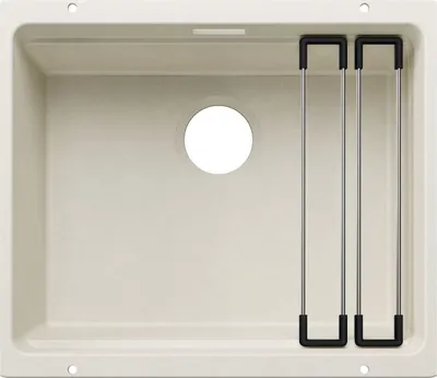 A top-down view of a beige kitchen sink with a circular drain hole and a metal rack with black handles resting inside.