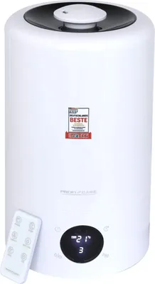 A white humidifier with a black top and a remote control in front of it. A digital display shows '21' and '3'. There is a seal of 'TEST DEUTSCHLANDS BESTE' on the front.