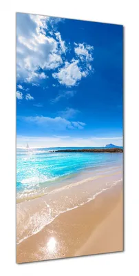 A beach scene with a bright blue sky, turquoise water, and a sandy shore.