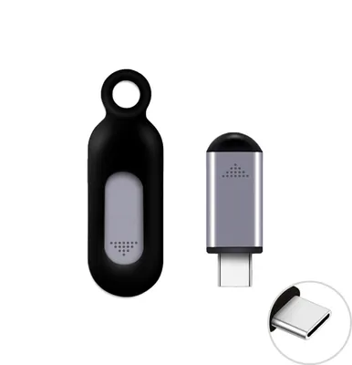 Two electronic accessories are displayed on a white background. One is a black, oval-shaped device with a loop at the top and a gray oval insert. The other is a silver, rectangular device with a black top and a USB-C connector at the bottom. A close-up of