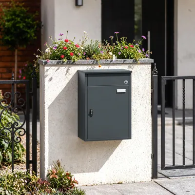 SoBuy Paketbox OGS65-DG in Dark Gray an Hauswand mit Blumen und schwarzem Gitter
