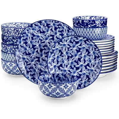A set of blue and white patterned ceramic plates and bowls are stacked and arranged on a white background.