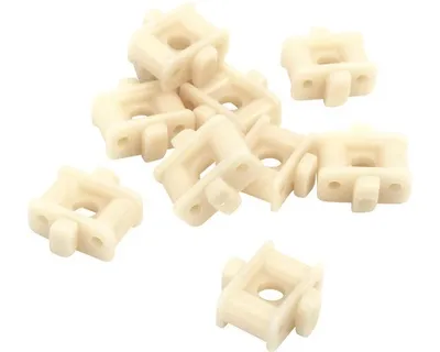 A pile of small, cream-colored plastic plant holders on a white background.