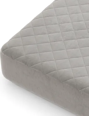 A close-up, angled view of a quilted mattress protector on a white background.