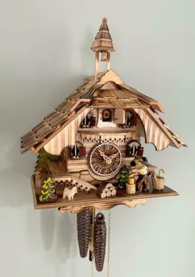 A detailed cuckoo clock made of wood, with figurines and decorative elements.