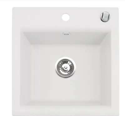 A top-down view of a white kitchen sink with a silver drain.